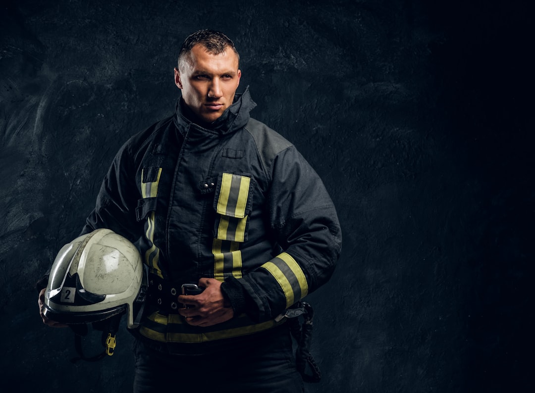 a man in a firemans uniform holding a helmet