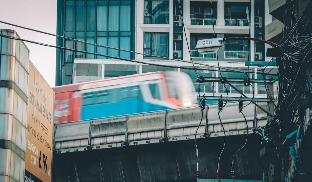 a train traveling over a bridge next to a tall building