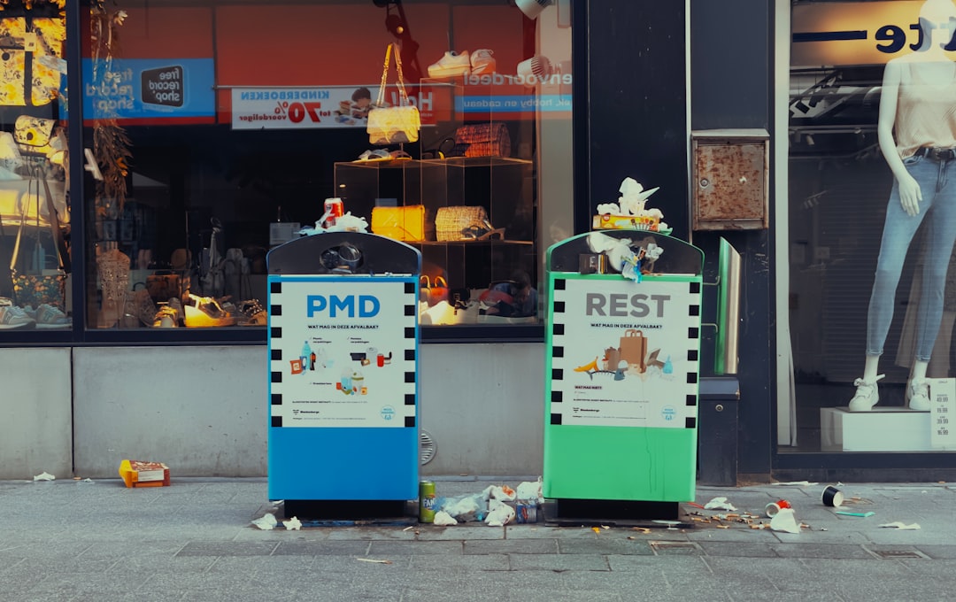 a couple of trash cans sitting on the side of a road